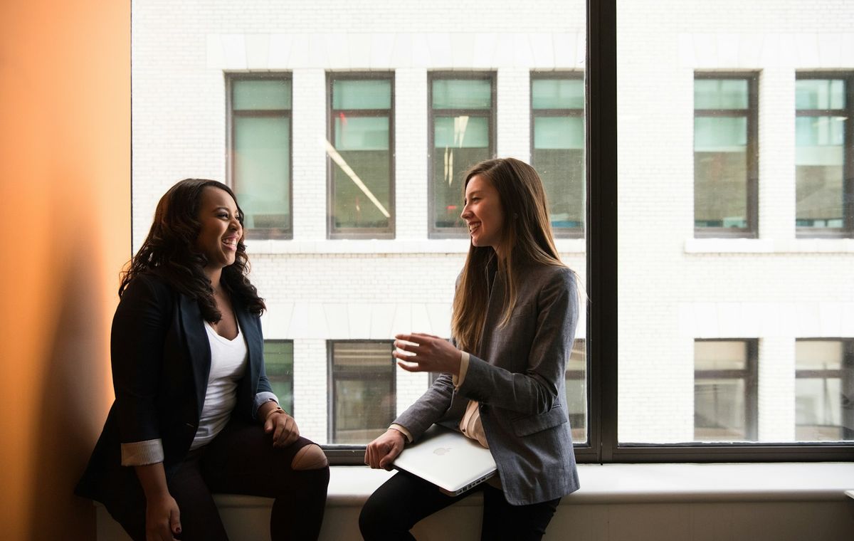 Two colleagues in conversation by an office window